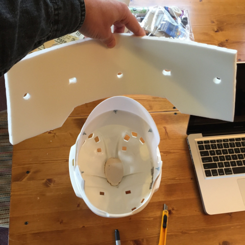 The rough-cut blank craft foam with 1/2" holes drilled to clear the screws protruding inside the visor shell. 