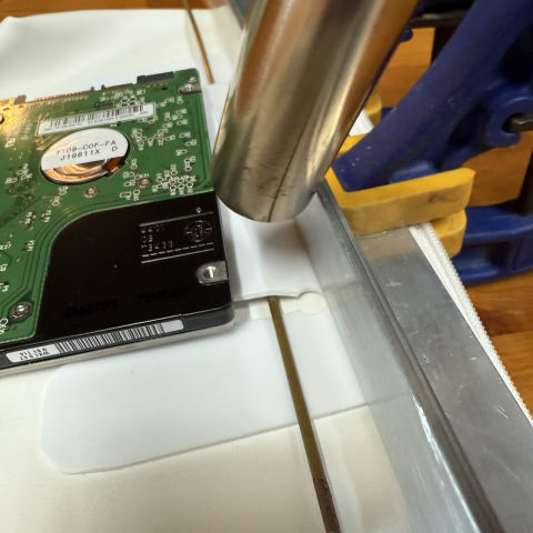 Heat gun and piece of clothes hanger to shape the belt clip. Old hard drive - very TRONish? - to press down.