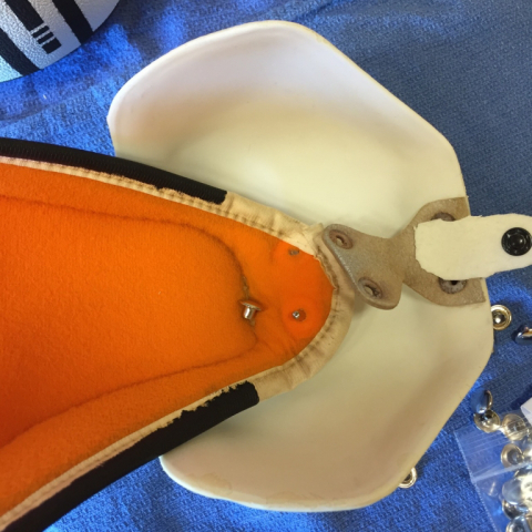 Using double headed rivets to fasten shoulder cup to arm pad.