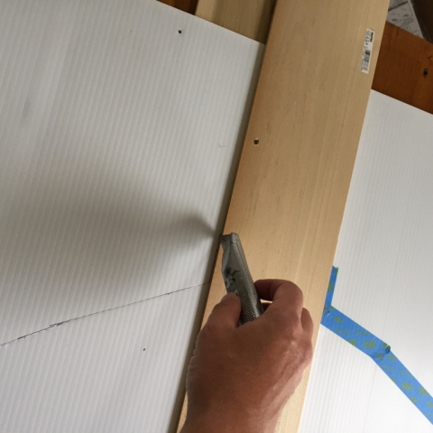 Using a straight edge and utility knife to cut the corrugated vinyl.  I placed a cut board underneath.