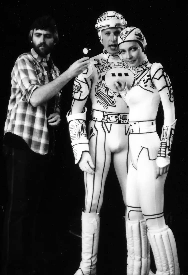 Shooting Tron (1982), Logan checks his light on actors Bruce Boxleitner and Cindy Morgan.
