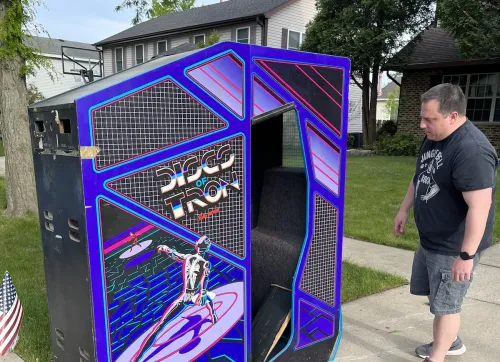 Chris Lapetino inspects the “Discs of Tron” arcade game that his brother Tim discovered on a Chicago-area sidewalk. (Tim Lapetino)